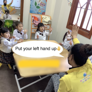 Put your left hand upの声に自分の左を確認して左をあげる生徒たち。