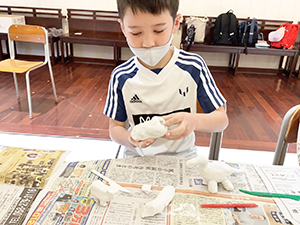 紙粘土で恐竜を作る子ども