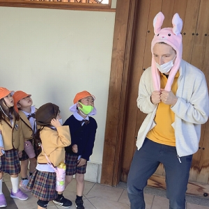 ウサギの帽子をかぶる先生とそれを見ている生徒たち