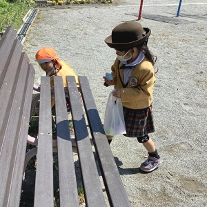 公園のベンチ周辺で卵を探す生徒
