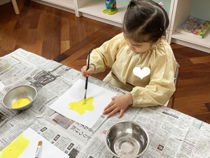 黄色の絵の具を塗る生徒