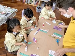 段ボールと折り紙で枠を作る生徒たち