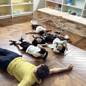 床に横になる先生と生徒たち