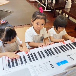 友だちと一緒に電子ピアノを弾く生徒