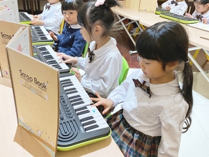 お友だちと電子ピアノの合奏をする生徒たち