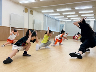ダンスレッスンで腰を低くしてポーズを取る生徒たち