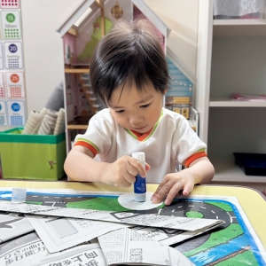 折り紙の裏に熱心にのりを塗る生徒