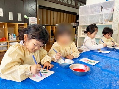 絵の具を混ぜながら塗る子どもたち