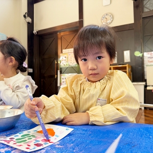 絵の具を塗りながら微笑む生徒