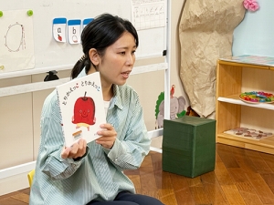 絵本を生徒たちに読み聞かせする先生