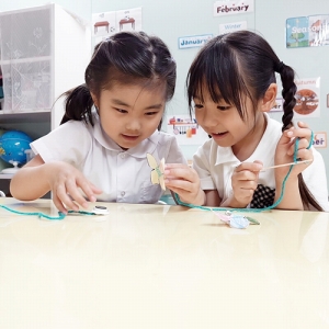 手作りのちょうちょに磁石がくっつく様子を観察する生徒たち