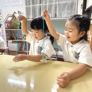 磁石でちょうちょを吊り上げて喜ぶ生徒たち