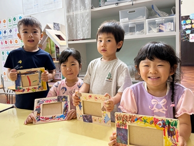 手作りしたフォトフレームを見せて微笑む子どもたち