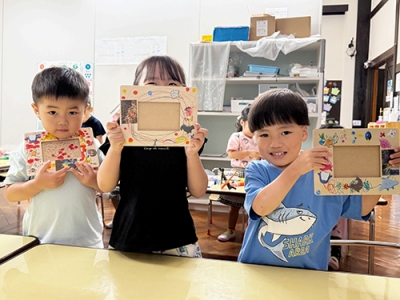 手作りしたフォトフレームを少し恥ずかしそうに見せる子どもたち