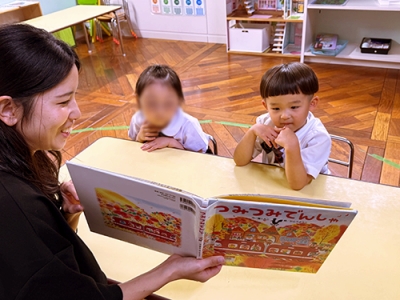田中先生に絵本を読み聞かせをしてもらう生徒たち