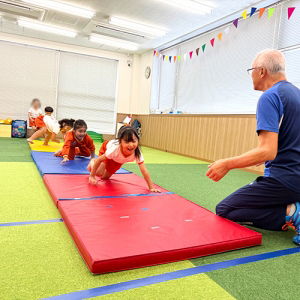 体育の授業でマット運動をする生徒