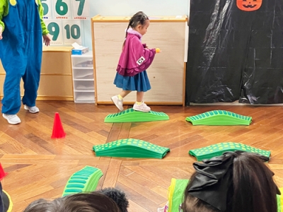 ハロウィーンオブスクタルで平均台を渡る子ども