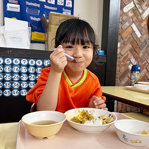 一口食べて微笑む生徒