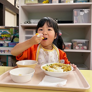 大きな口で給食を頬張る生徒