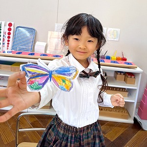 完成した蝶のクラフトを見せる生徒