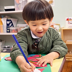 笑顔で作品に描き込む生徒