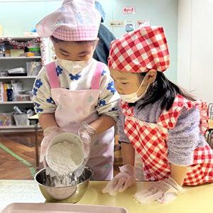 ボールに小麦粉を入れる生徒たち
