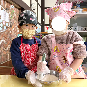 お友だちと一緒にボールの中の材料を混ぜる生徒たち