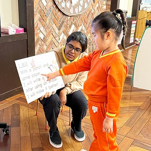 英語が書かれたボードを指さしながら答える生徒