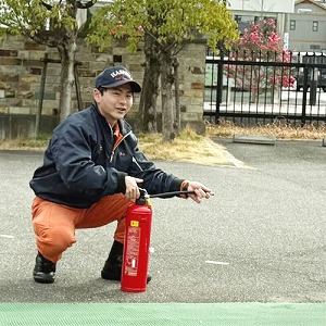 消火器の使い方を指導する消防士