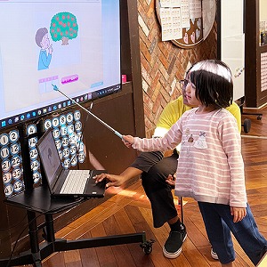 差し棒でモニターを示す生徒