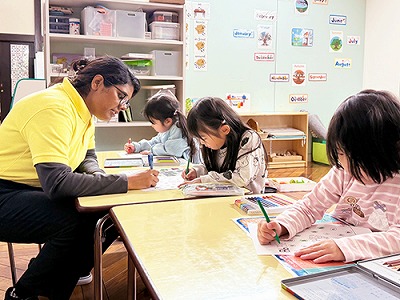 先生と一緒に英検対策の勉強をする生徒たち