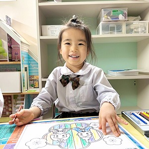 ひなまつりの塗り絵が完成して笑顔を見せる生徒