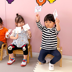 動物カードを両手に持って掲げる生徒たち