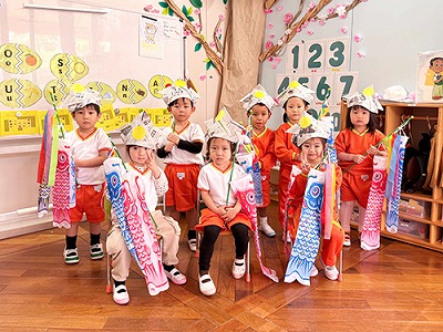 兜をかぶり鯉のぼりを持ってみんなで記念撮影