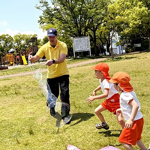 シャボン玉で遊ぶ生徒たちと先生