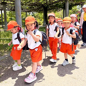 リュックサックを背負ってお友だちと手を繋いで歩く生徒たち
