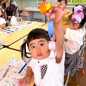 作った七夕の輪飾りを見せる生徒
