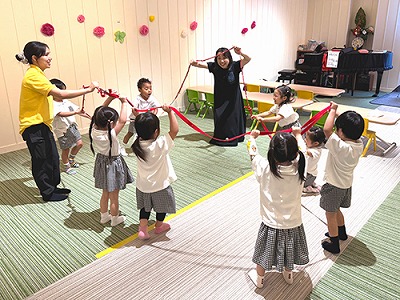 鈴のついた輪になったひもを持つ生徒たち