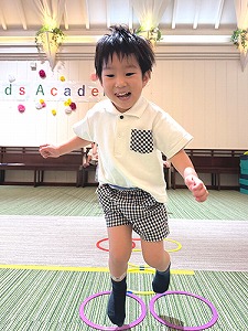 リトミックで音楽に合わせてけんけんぱする生徒