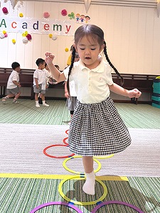 リトミックで音楽に合わせてけんけんぱする生徒