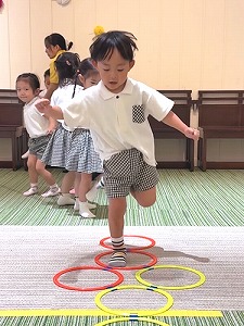 リトミックで音楽に合わせてけんけんぱする生徒