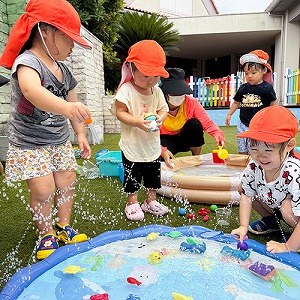 プールの周りで水遊びをする子どもたち