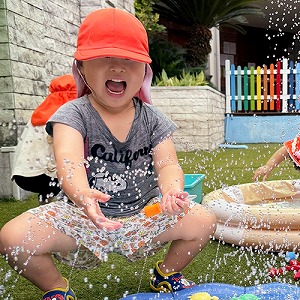 笑顔で水遊びをする子ども