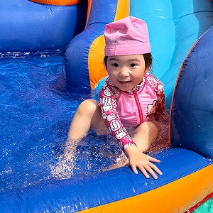 プールの滑り台を滑る生徒