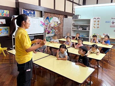 先生から風車作りの説明を聞く生徒たち