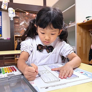 色鉛筆で色を塗る生徒