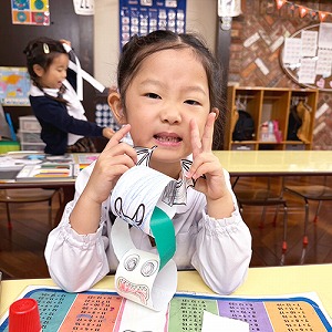 完成した輪飾りを見せる生徒